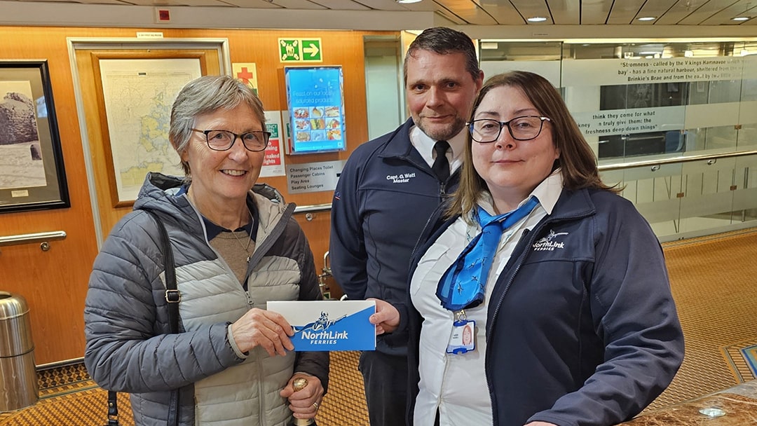 Elizabeth Flett, the 200,000th passenger on MV Hamnavoe in 2024, is pictured with Gary Watt, Master, MV Hamnavoe and Karen Riddell, Purser, MV Hamnavoe