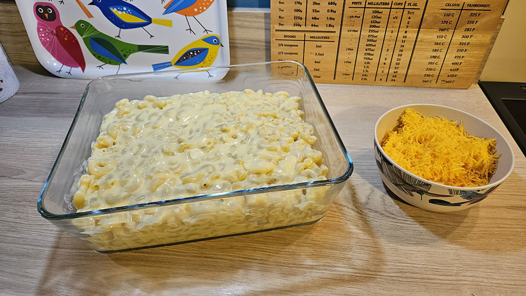 The macaroni cheese in a baking dish, ready for grated cheese to be sprinkled on top